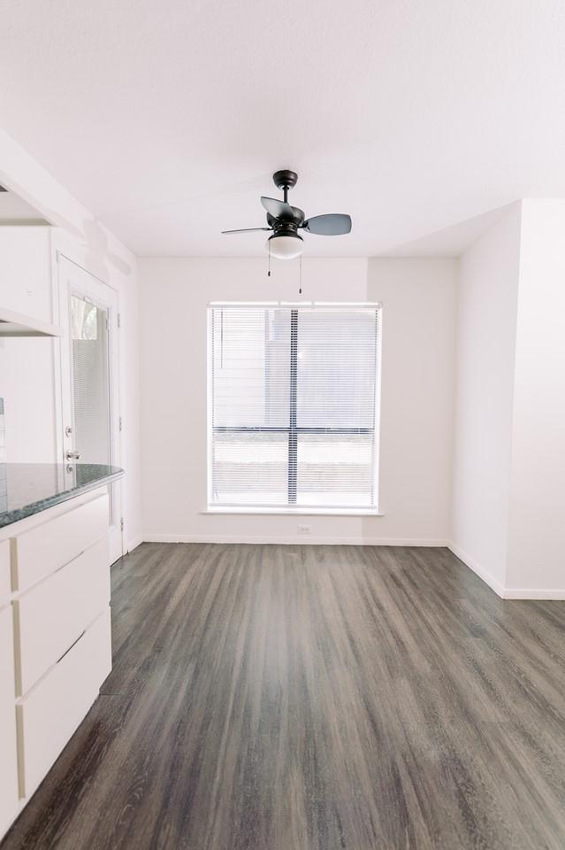 6646 E Lovers Ln Unit 301, Dallas, TX 75214 - unfurnished living room with dark wood-style floors, healthy amount of natural light, and baseboards