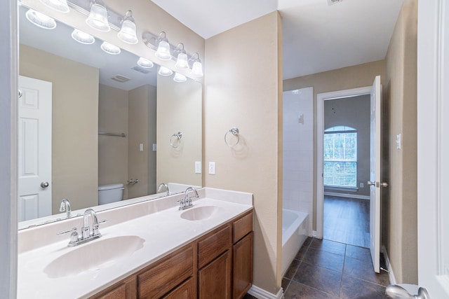 7001 Bickers Dr, Rowlett, TX 75089 - full bath with double vanity, tile patterned floors, toilet, and tub / shower combination