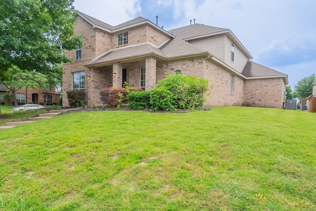 7001 Bickers Dr, Rowlett, TX 75089 - traditional-style house featuring brick siding, a front yard, and central air condition unit