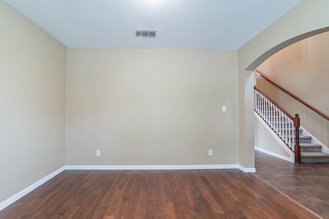 7001 Bickers Dr, Rowlett, TX 75089 - unfurnished room with arched walkways, wood finished floors, baseboards, and stairway