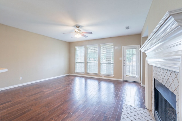 7001 Bickers Dr, Rowlett, TX 75089 - unfurnished living room featuring a tiled fireplace, ceiling fan, wood finished floors, and baseboards