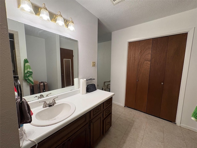 1605 NE 17th, Paris, TX 75460 - bathroom featuring vanity, a textured ceiling, and tile patterned flooring