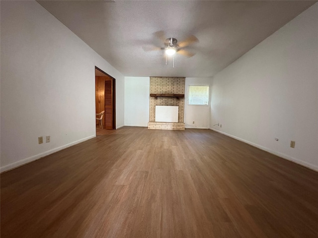1605 NE 17th, Paris, TX 75460 - unfurnished living room featuring a ceiling fan, wood finished floors, a fireplace, and baseboards