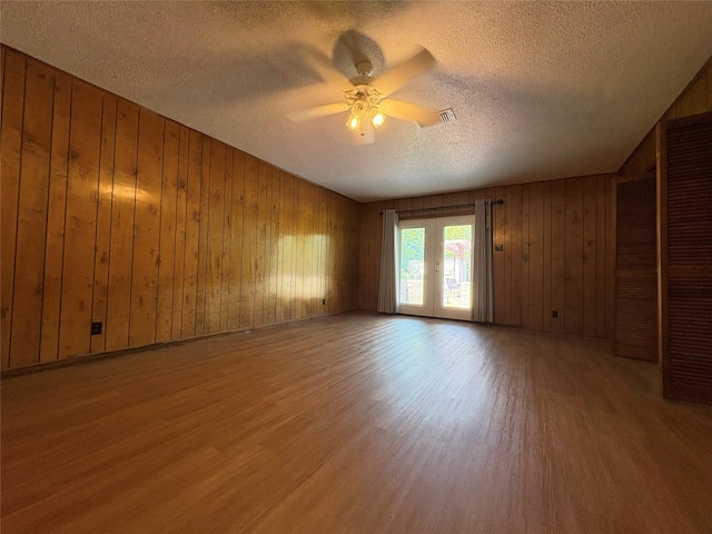 1605 NE 17th, Paris, TX 75460 - empty room with wood finished floors, a textured ceiling, ceiling fan, and wood walls