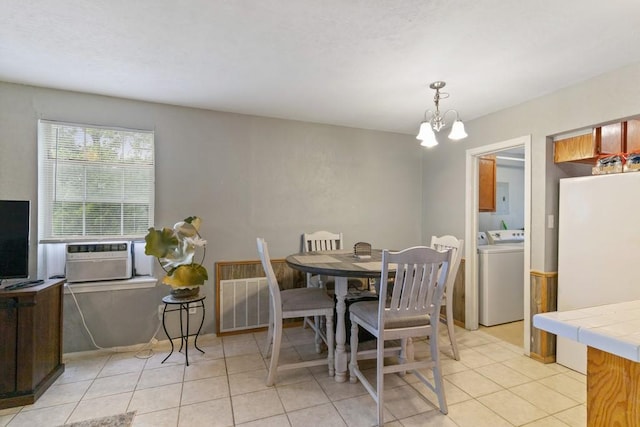 813 Pine St, Teague, TX 75860 - dining area with washer / dryer, light tile patterned flooring, and a chandelier