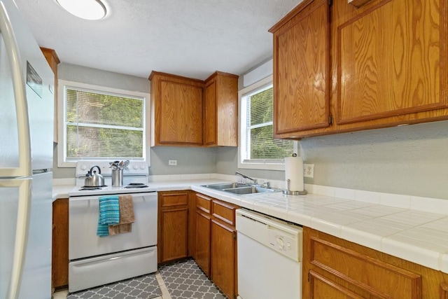 813 Pine St, Teague, TX 75860 - kitchen with white appliances, brown cabinetry, and light countertops