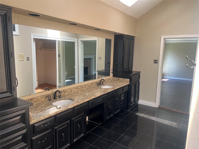 4158 Briargrove Ln, Dallas, TX 75287 - full bath featuring double vanity, tile patterned flooring, vaulted ceiling, baseboards, and toilet