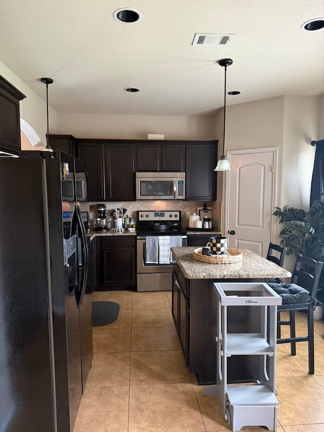5001-5003 Sanger Circle Dr, Sanger, TX 76266 - kitchen with appliances with stainless steel finishes, a center island, backsplash, light tile patterned floors, and decorative light fixtures