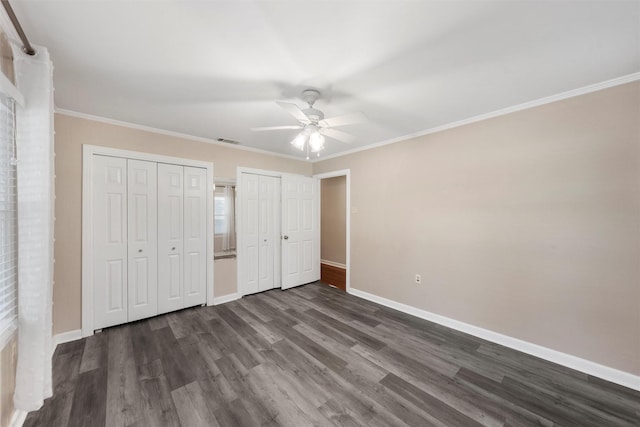 2225 Wooded Acres Dr, Waco, TX 76710 - unfurnished bedroom featuring multiple closets, dark wood-style flooring, ceiling fan, and ornamental molding