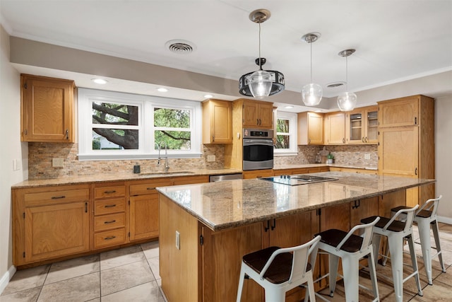 2225 Wooded Acres Dr, Waco, TX 76710 - kitchen featuring appliances with stainless steel finishes, a kitchen island, backsplash, light stone countertops, and ornamental molding