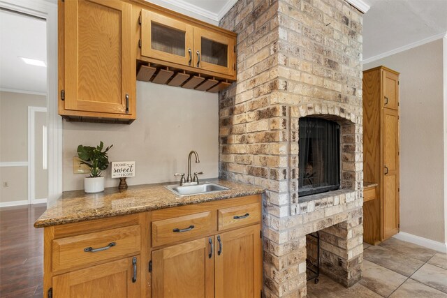 2225 Wooded Acres Dr, Waco, TX 76710 - kitchen featuring a fireplace, crown molding, glass insert cabinets, and stone countertops