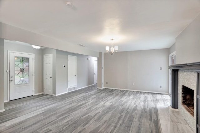 1510 Bowie St, Garland, TX 75042 - unfurnished living room with a chandelier, a stone fireplace, and light wood finished floors