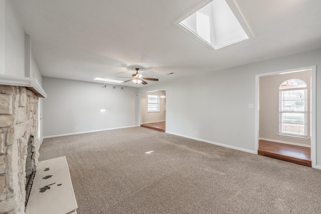 708 Simpson Ter, Bedford, TX 76021 - unfurnished living room with a skylight, carpet floors, a ceiling fan, and baseboards