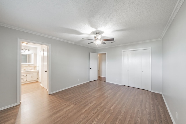 708 Simpson Ter, Bedford, TX 76021 - unfurnished bedroom featuring wood finished floors, a closet, a textured ceiling, baseboards, and crown molding