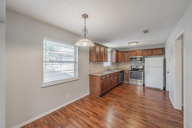 708 Simpson Ter, Bedford, TX 76021 - kitchen featuring stainless steel appliances, a sink, dark wood-style floors, backsplash, and a textured ceiling