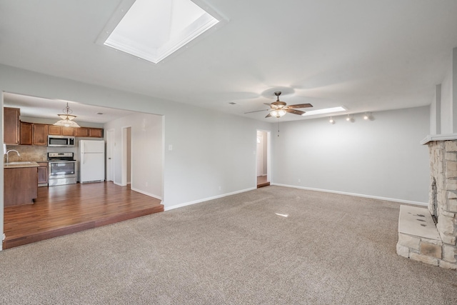 708 Simpson Ter, Bedford, TX 76021 - unfurnished living room with a skylight, a sink, carpet, and a fireplace