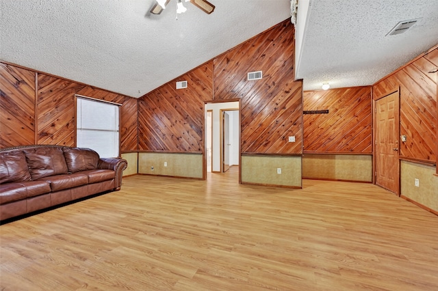 344 Trail Rd, Denison, TX 75021 - living room with a textured ceiling, lofted ceiling, wood walls, ceiling fan, and wood finished floors