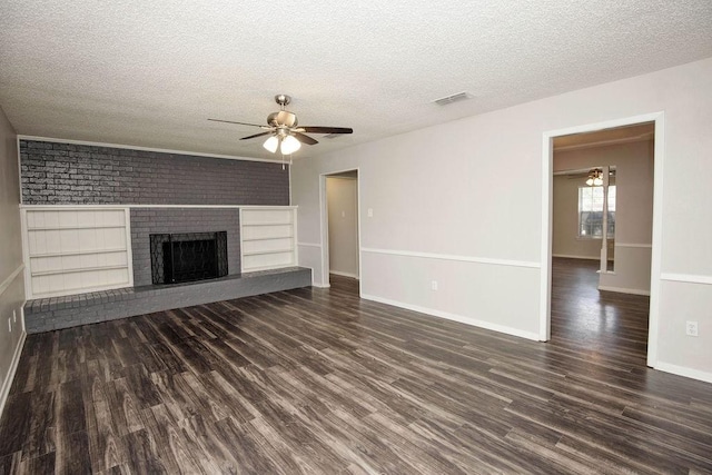 4209 W Pleasant Forest St, Arlington, TX 76015 - unfurnished living room with ceiling fan, dark wood-type flooring, a textured ceiling, and a brick fireplace