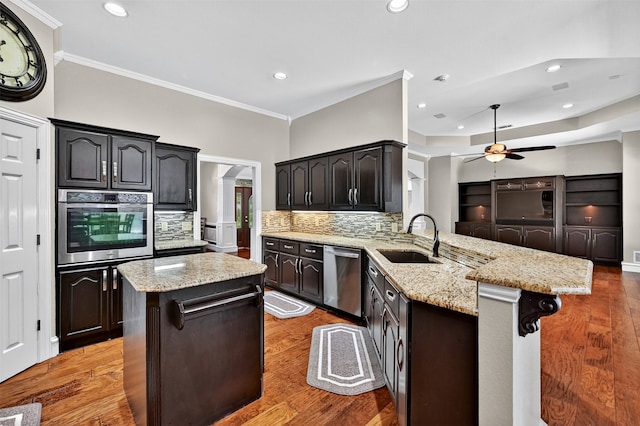 688 Lazy Acres Cir, Pottsboro, TX 75076 - kitchen with stainless steel appliances, a sink, a peninsula, ceiling fan, and backsplash