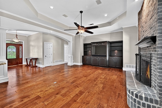 688 Lazy Acres Cir, Pottsboro, TX 75076 - unfurnished living room featuring a tray ceiling, arched walkways, a ceiling fan, ornate columns, and recessed lighting