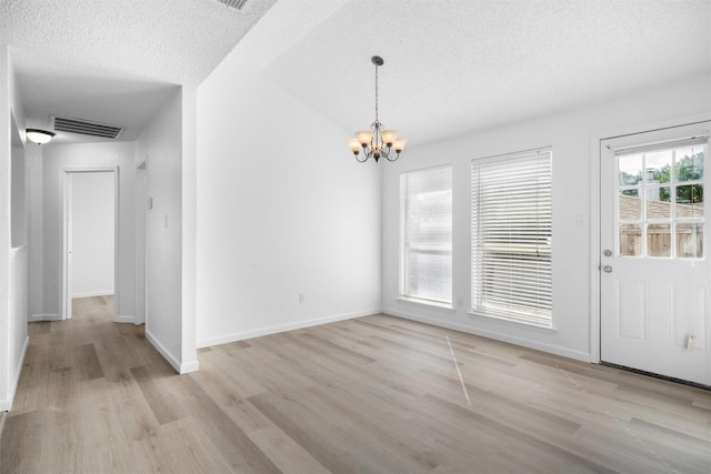 10228 Maverick Dr, Fort Worth, TX 76108 - unfurnished dining area featuring a chandelier, a textured ceiling, and light wood-type flooring