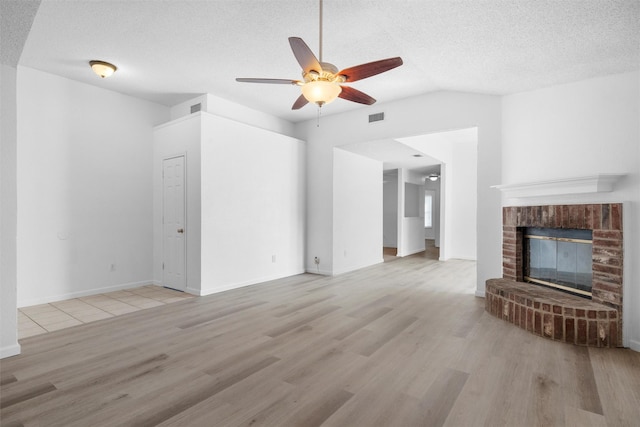 10228 Maverick Dr, Fort Worth, TX 76108 - unfurnished living room with ceiling fan, a textured ceiling, light wood finished floors, a fireplace, and lofted ceiling