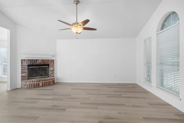 10228 Maverick Dr, Fort Worth, TX 76108 - unfurnished living room featuring lofted ceiling, a ceiling fan, wood finished floors, and a brick fireplace
