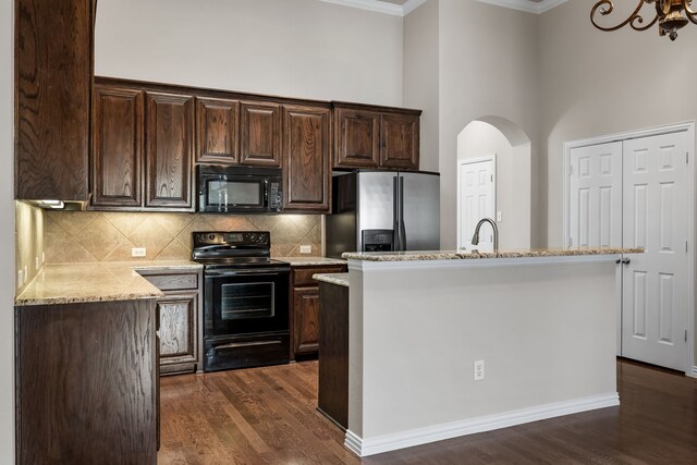 3075 Willow Grove Blvd Unit 2302, Mckinney, TX 75070 - kitchen featuring black appliances, crown molding, dark wood-style floors, dark brown cabinets, and decorative backsplash
