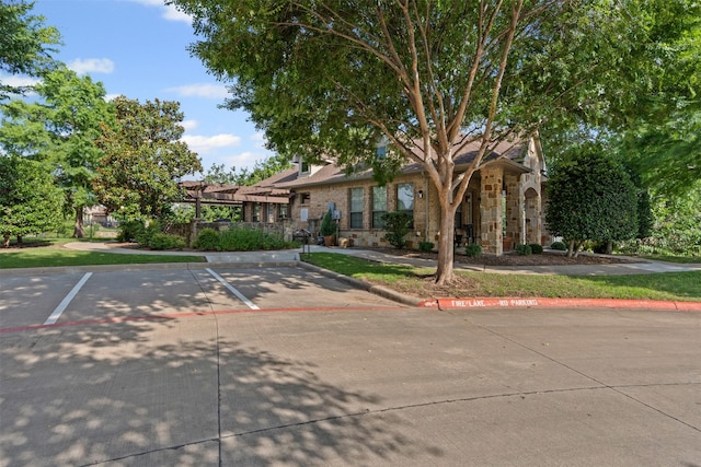 3075 Willow Grove Blvd Unit 2302, Mckinney, TX 75070 - obstructed view of property with a pergola, uncovered parking, and stone siding