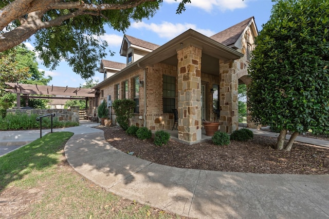 3075 Willow Grove Blvd Unit 2302, Mckinney, TX 75070 - view of home's exterior featuring stone siding, brick siding, a shingled roof, and a pergola