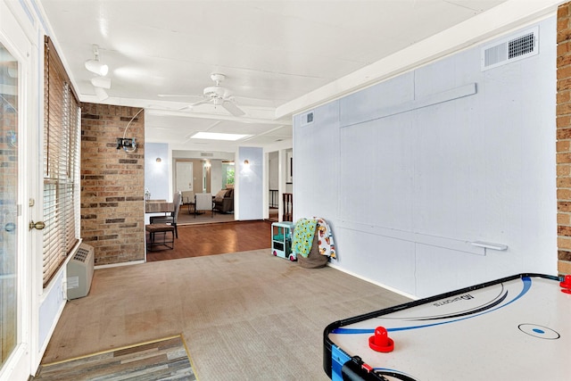 1305 Jabbet Dr, Plano, TX 75025 - recreation room featuring a ceiling fan, wood finished floors, and brick wall