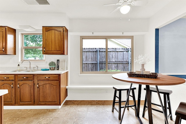 1305 Jabbet Dr, Plano, TX 75025 - kitchen featuring brown cabinetry, ceiling fan, and light countertops