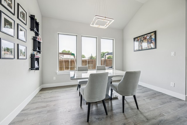 3205 Tradition Ct, Rowlett, TX 75088 - dining space featuring lofted ceiling, baseboards, wood finished floors, and a chandelier