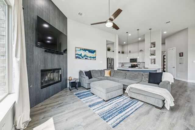 3205 Tradition Ct, Rowlett, TX 75088 - living area featuring wood finished floors, a ceiling fan, a tile fireplace, recessed lighting, and baseboards