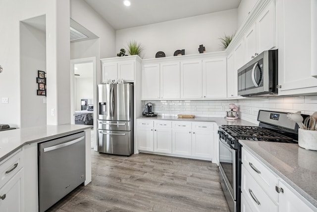 3205 Tradition Ct, Rowlett, TX 75088 - kitchen with stainless steel appliances, white cabinetry, decorative backsplash, and recessed lighting