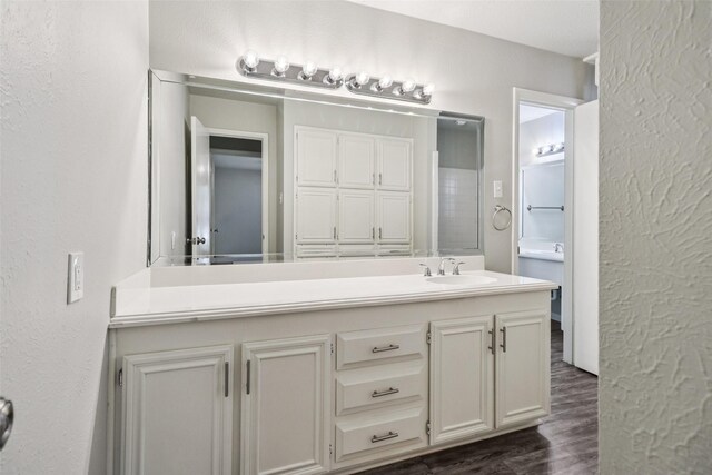 2201 Briarwood Blvd, Arlington, TX 76013 - bathroom with wood finished floors, vanity, and a textured wall