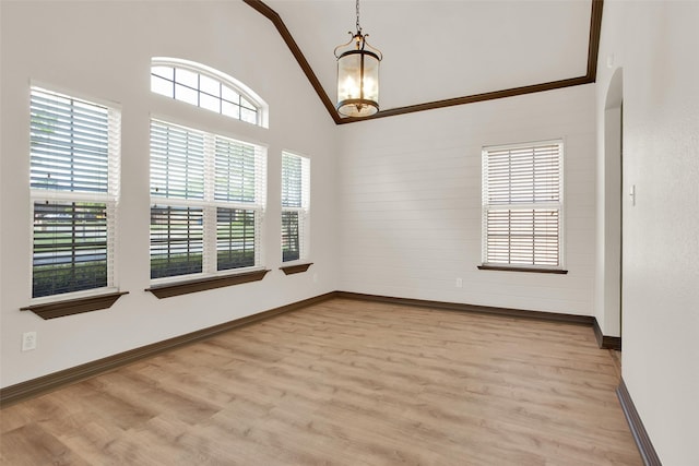 2111 Renaissance Dr, Denison, TX 75020 - empty room with plenty of natural light, a chandelier, wood finished floors, baseboards, and high vaulted ceiling