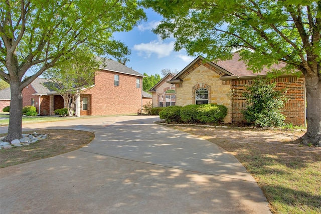 2111 Renaissance Dr, Denison, TX 75020 - traditional-style house featuring brick siding, stone siding, and curved driveway