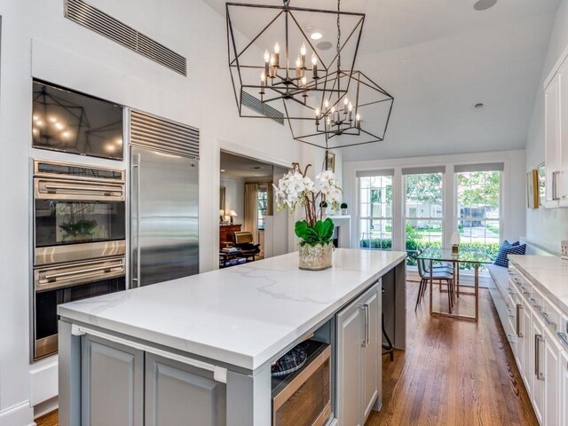 4604 Southern Ave, Highland Park, TX 75209 - kitchen with built in appliances, gray cabinetry, a center island, a chandelier, and a towering ceiling