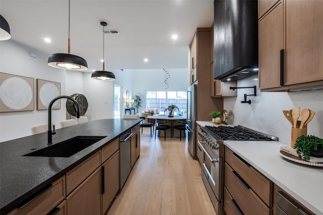 4322 Sexton Ln, Dallas, TX 75229 - kitchen with exhaust hood, appliances with stainless steel finishes, a sink, light wood finished floors, and decorative light fixtures
