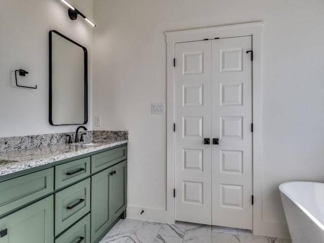 6434 Abner Rd, Terrell, TX 75161 - bathroom featuring marble finish floors, double vanity, a freestanding tub, and baseboards