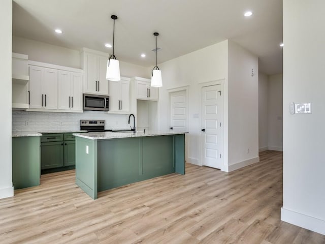 6434 Abner Rd, Terrell, TX 75161 - kitchen with stainless steel microwave, electric range oven, decorative backsplash, light wood finished floors, and green cabinets