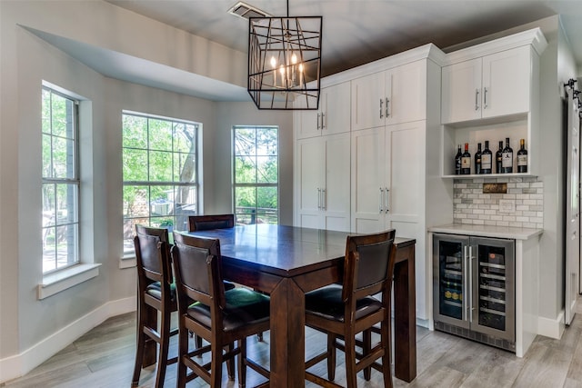 711 Majestic Oaks Dr, Oak Point, TX 75068 - dining room featuring beverage cooler, healthy amount of natural light, a chandelier, and a bar