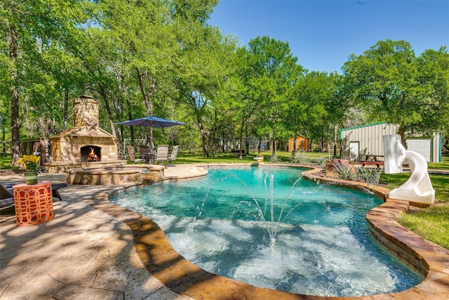 711 Majestic Oaks Dr, Oak Point, TX 75068 - view of pool featuring an outdoor stone fireplace, a patio, a pool with connected hot tub, view of scattered trees, and a shed