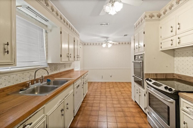 1506 Ridgeview Dr, Arlington, TX 76012 - kitchen featuring stainless steel electric stove, ceiling fan, wall oven, wallpapered walls, and a sink