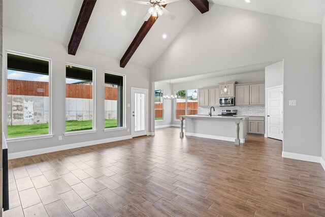 207 Mitchell Dr, Glen Rose, TX 76043 - unfurnished living room with high vaulted ceiling, beam ceiling, ceiling fan, recessed lighting, and wood finished floors