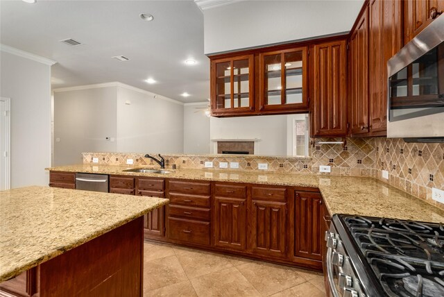3616 Canyon Oaks Dr, Carrollton, TX 75007 - kitchen featuring stainless steel appliances, crown molding, decorative backsplash, light stone countertops, and a fireplace