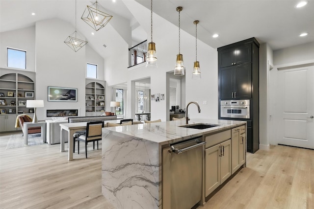 5901 Westworth Falls Way, Westworth Village, TX 76114 - kitchen with stainless steel appliances, a sink, high vaulted ceiling, a kitchen island with sink, and light stone counters