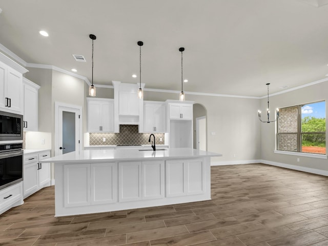 971 County Road 1304, Bridgeport, TX 76426 - kitchen with stainless steel appliances, ornamental molding, light countertops, backsplash, and a large island with sink