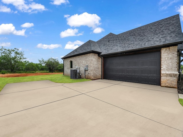 971 County Road 1304, Bridgeport, TX 76426 - view of side of home with brick siding, central air condition unit, driveway, a lawn, and an attached garage